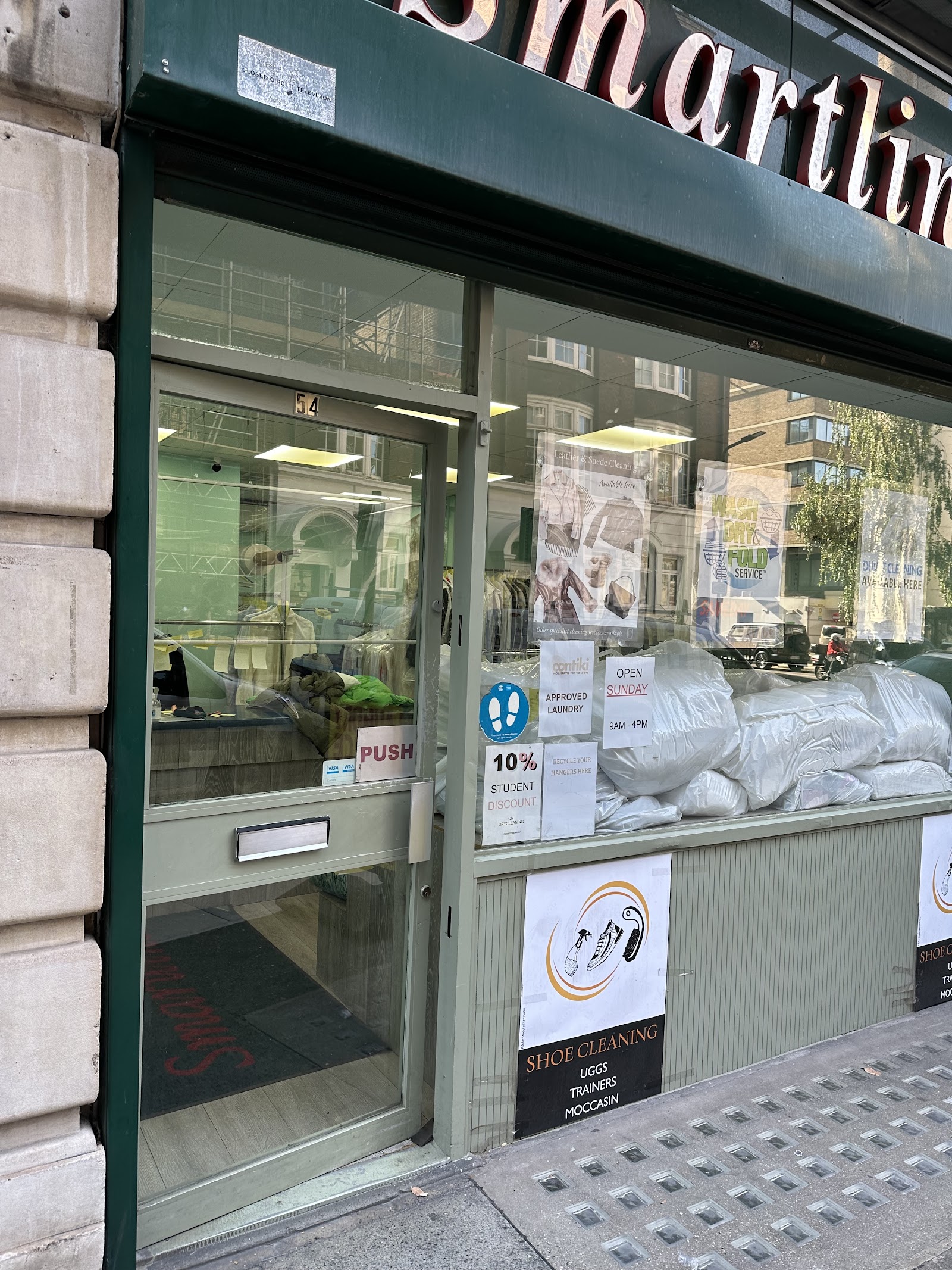 Smartline Dry Cleaners storefront on Coram Street, with deep green frame and cream interior, photographed by Yibing Dong